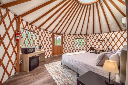 a bedroom with a bed and a tv in a yurt at OT 3515A Texas Yurt Haus Armadillo in New Braunfels