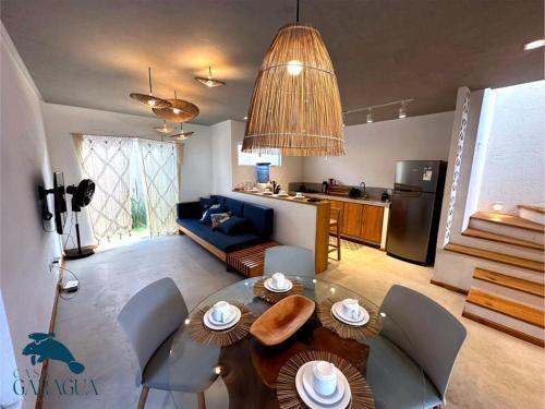 a living room with a dining table and a kitchen at Casa a 1200m da Praia do Patacho - Casa Garaguá in Pôrto de Pedras