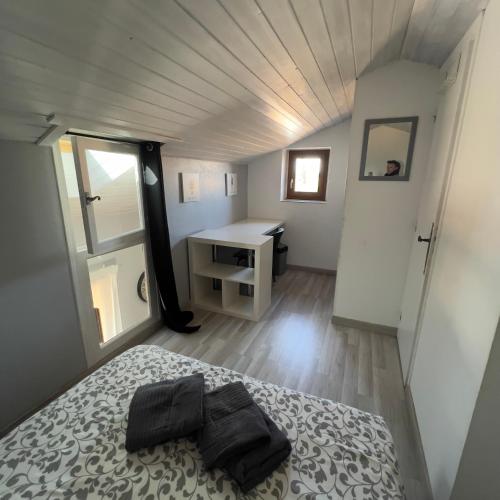 a bedroom with a bed and a desk in it at Joli appartement et terrasse vue sur les dentelles in Sablet