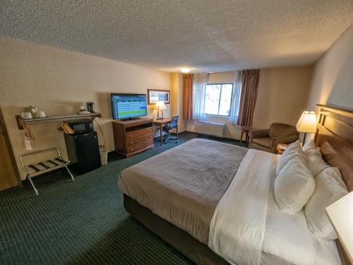 a hotel room with a bed and a flat screen tv at Comfort Inn Near Vail Beaver Creek in Avon