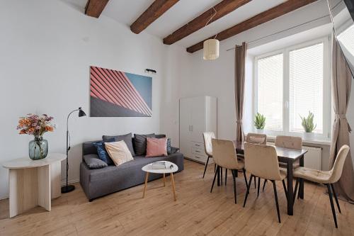 クラクフにあるUrban Nest Apartments Szewska 21のソファとテーブルと椅子のあるリビングルーム