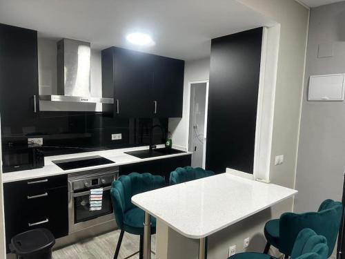 a kitchen with black cabinets and a table and chairs at Bungalow a 200 m de la Playa in Arenales del Sol