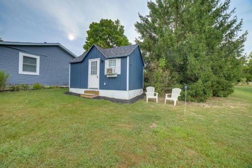 a blue house with two chairs in a yard at Dumont Lake Studio Boat, Fish and Unwind! in Allegan