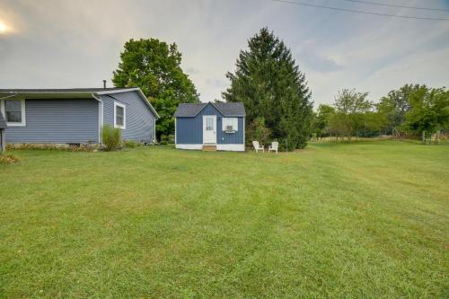 a yard with a blue house and a grass field at Dumont Lake Studio Boat, Fish and Unwind! in Allegan