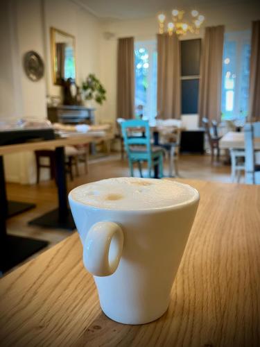 a cup of coffee sitting on top of a table at Li Ter Hôtel in Marche-en-Famenne
