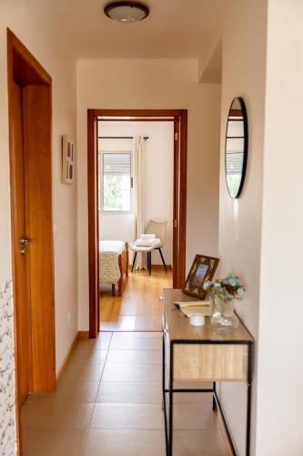 a hallway with a table and a living room at Sentidos do Mar - Apartamento em São Miguel in Calhetas