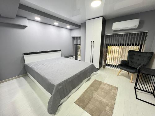 un dormitorio con una cama y una silla en NJ Luxury Room, en Varna