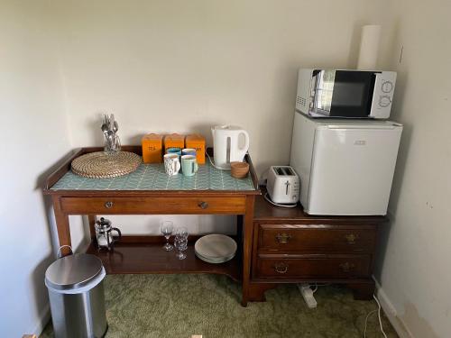 a table with a microwave and a refrigerator at Bryntirion Farmhouse Rooms (with bathroom) in Llanfair Caereinion