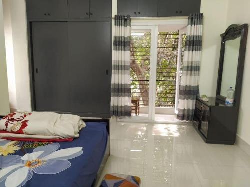 a bedroom with a bed and a mirror and a door at luxurious apartmnt in city centre in Sylhet