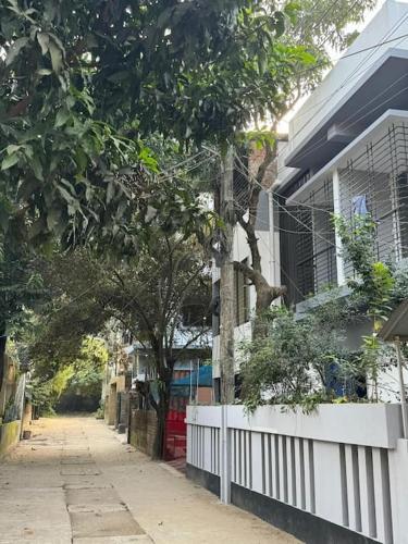 a street with a white fence next to a house at luxurious apartmnt in city centre in Sylhet