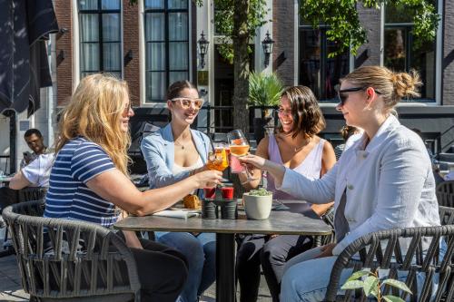 a group of women sitting at a table drinking wine at Mister Highland Hotel in Amsterdam
