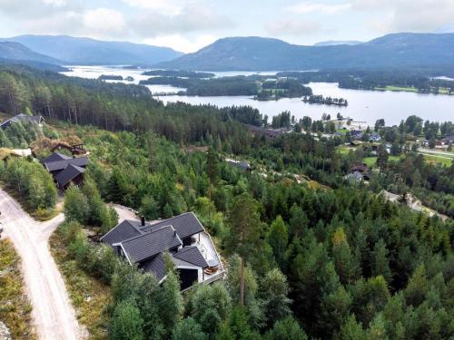 a house on a hill with a view of a lake at Verhøf Hytte - 9p - With Sauna & Hot Tub in Vradal