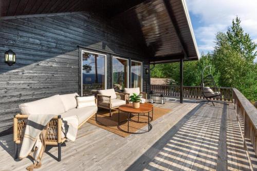 a deck with a couch and chairs on a house at Verhøf Hytte - 9p - With Sauna & Hot Tub in Vradal