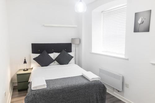 une chambre blanche avec un lit et une fenêtre dans l'établissement Leeds City Centre New Apartment, à Leeds