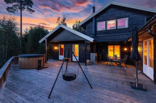 a house with a wooden deck with at Verhøf Hytte - 9p - With Sauna & Hot Tub in Vradal