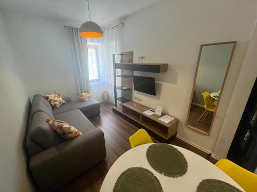 a living room with a couch and a television at Kikelet Udvarház in Zánka