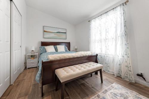 a bedroom with a bed with a bench and a window at 10 Min Drive to the Sequoias in Three Rivers