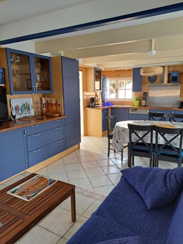 un salon avec un canapé et une cuisine dans l'établissement maison de vacances bord de mer, à Camaret-sur-Mer