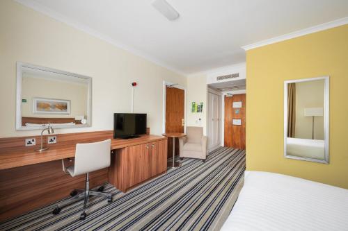 a hotel room with a desk and a television at Holiday Inn Glasgow - East Kilbride by IHG in East Kilbride