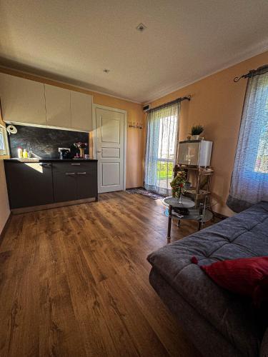 an empty living room with a kitchen and a couch at Kikī namiņš in Sigulda
