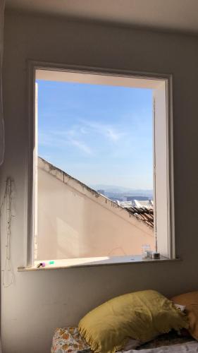 里约热内卢Quarto com varanda no paraíso的卧室内的窗户,享有海景