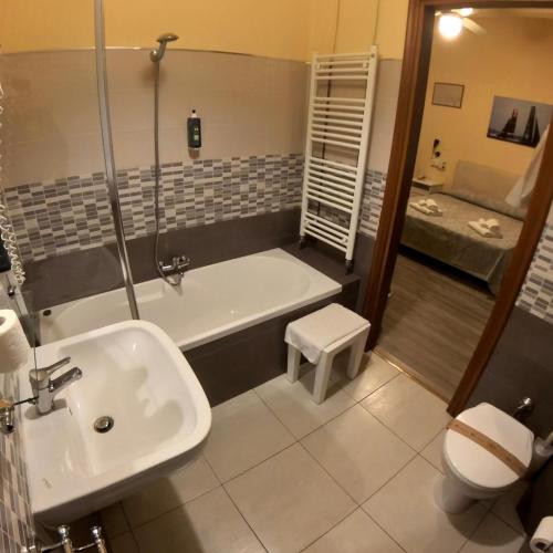 a bathroom with a tub and a toilet and a sink at Giappone Inn Parking Hotel in Livorno