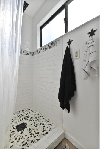 a bathroom with a shower with a black towel at Hathaway Hideaway Loft Apartment in Hathaway Pines