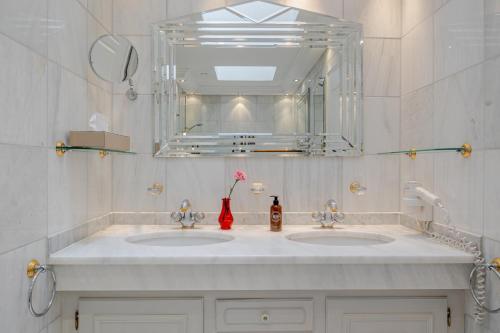 a bathroom with two sinks and a large mirror at Strönhof Kampen in Kampen