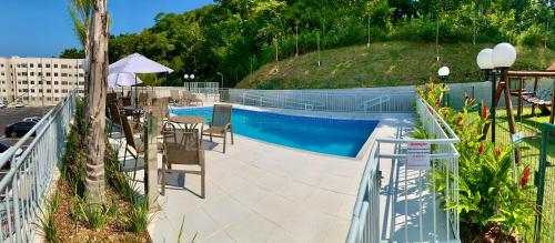 里约热内卢Conforto e natureza no Rio de Janeiro的带椅子、桌子和遮阳伞的游泳池