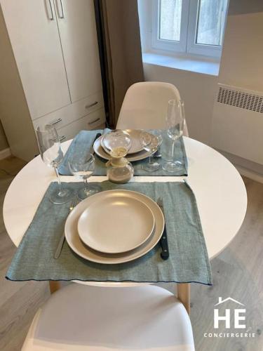 - une table blanche avec des assiettes et des verres dans l'établissement Dune - Balnéo - Netflix & Chill, à Montargis