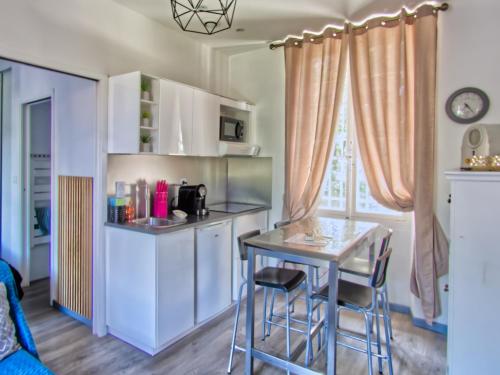 a small kitchen with a table and chairs in a room at La petite Maison in Grenoble