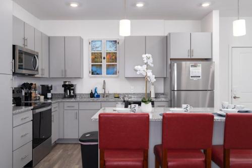 a kitchen with white cabinets and red chairs at Brand new Apt Oak Mt St Park Lots of Amenities in Pelham