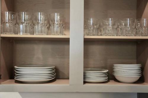 a shelf with plates and glasses in a cabinet at Brand new Apt Oak Mt St Park Lots of Amenities in Pelham