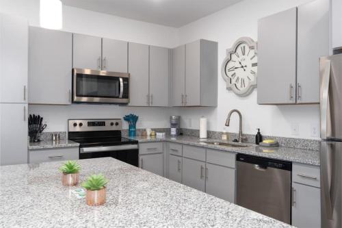 a kitchen with white cabinets and stainless steel appliances at Luxury 1 BR near Oak Mt State Park in Pelham