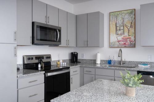 a kitchen with white cabinets and a stove top oven at NEW Apt Oak Mt St Park Great Amenities in Pelham