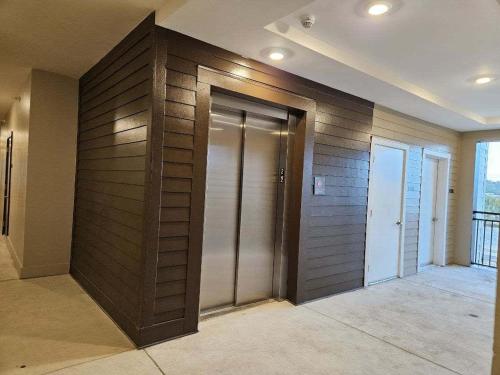 a room with a wooden wall with two elevator doors at NEW Apt Oak Mt St Park Great Amenities in Pelham