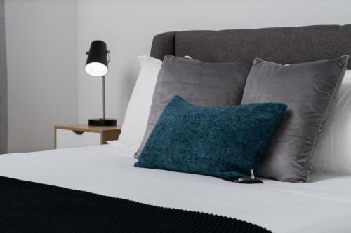a bed with a blue pillow and gray pillows at NEW Apt Oak Mt St Park Great Amenities in Pelham