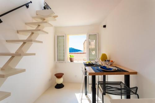 une petite cuisine avec une table et un escalier en colimaçon dans l'établissement LA CASETTA DI AZZURRA AP4427 By Riviera Holiday Homes, à Villefranche-sur-Mer