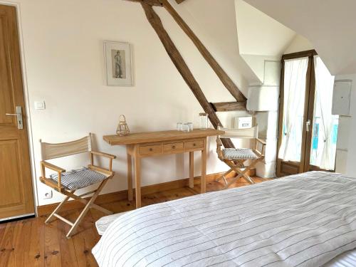 une chambre avec un lit, un bureau et des chaises dans l'établissement Le Moulin d Olivet, à Orbigny