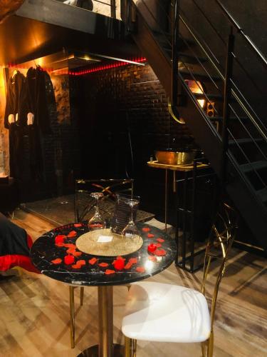 une table avec deux verres dans une pièce dans l'établissement L’Aphrodizia love room, à Barbaste