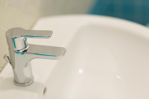a sink with a faucet in a bathroom at ControVento Rooms in Margherita di Savoia