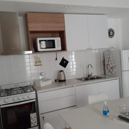 a small kitchen with a stove and a microwave at Monoambientes Magus in Junín