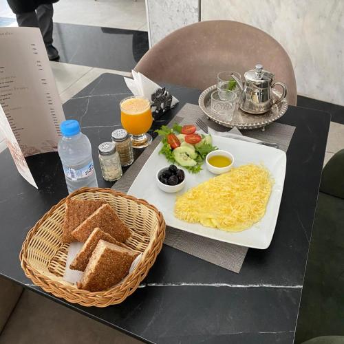 ケニトラにあるTown Roomsの食べ物の皿とバスケットが置かれたテーブル