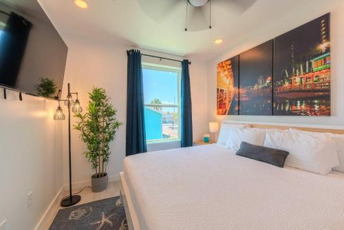 a bedroom with a white bed and a window at Marisol Condo 301 in South Padre Island