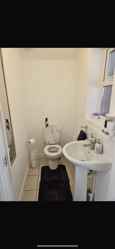a bathroom with a toilet and a sink at Nicely Furnished Rooms in Aylesbury in Weedon