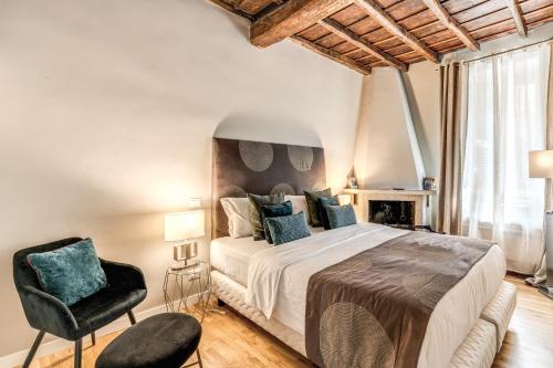 a bedroom with a large bed and a chair at Trevi Beau Boutique Hotel in Rome