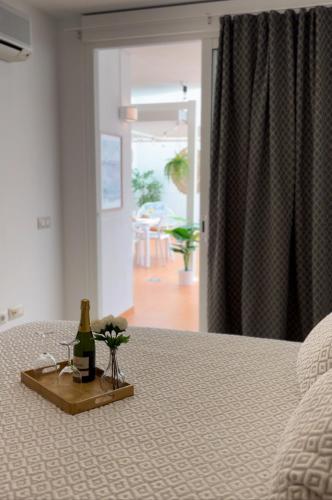 a bottle of wine and flowers on a bed at Vamos Tenerife - Playa La Arena - Puerto De Santiago in Puerto de Santiago