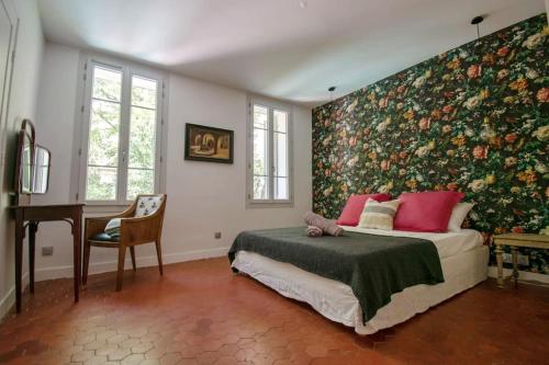 sypialnia z łóżkiem i kwiatową ścianą w obiekcie Magnifique maison de ville 6personnes , piscine et garage w Aix-en-Provence