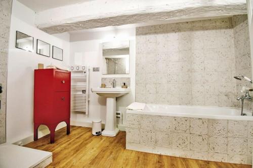 La salle de bains est pourvue d'une armoire rouge, d'une baignoire et d'un lavabo. dans l'établissement Magnifique maison de ville 6personnes , piscine et garage, à Aix-en-Provence