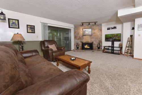a living room with a leather couch and a fireplace at Bearly Ober By Colonial Properties in Gatlinburg